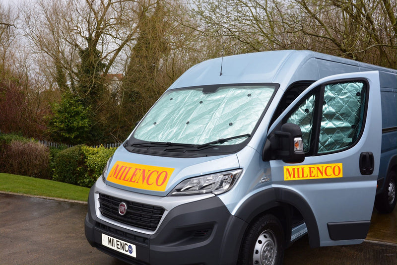 Milenco internal thermal blinds fitted to a van's windscreen and door window, viewed from outside