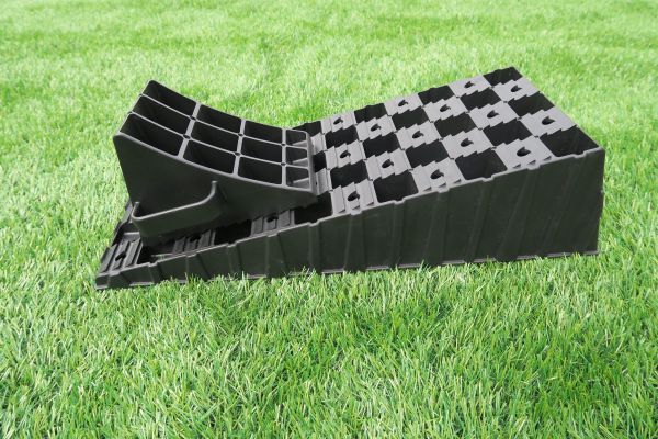Milenco MGI Wedge Level ramp with its matching wheel chock, on grass