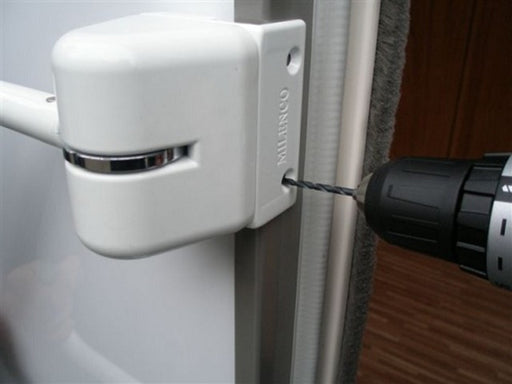 Milenco hand rail mounting bracket being drilled into a caravan door frame