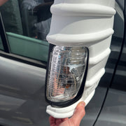 White Milenco mirror protector fitted to a Ford Transit mirror, close-up with indicator lens